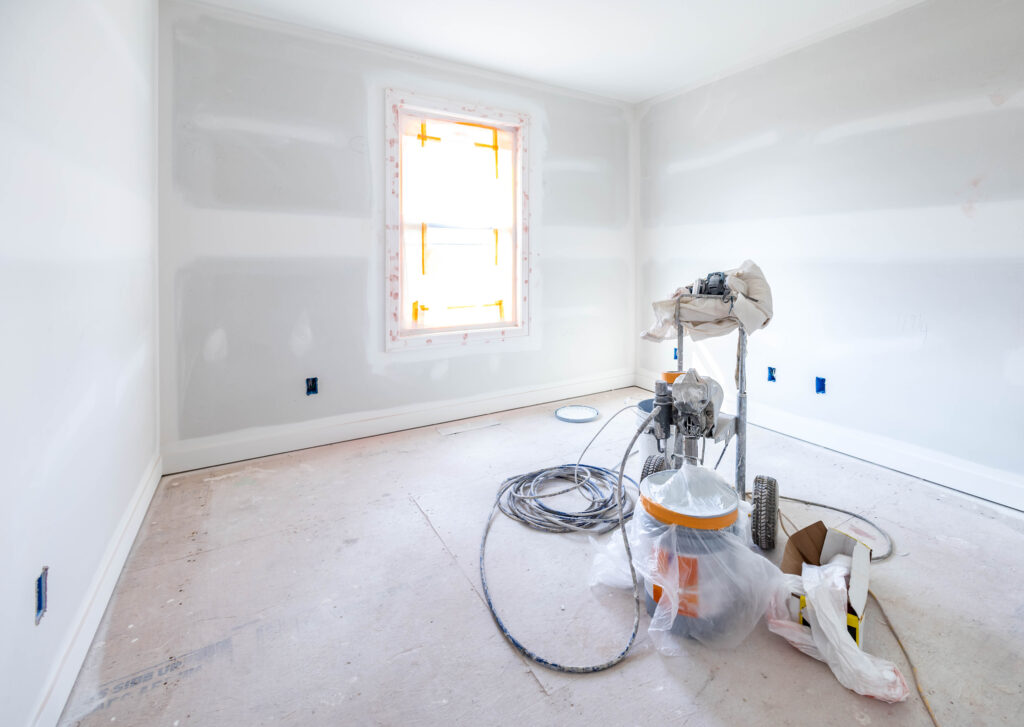 Painting equipment in the empty white room at the construction site.